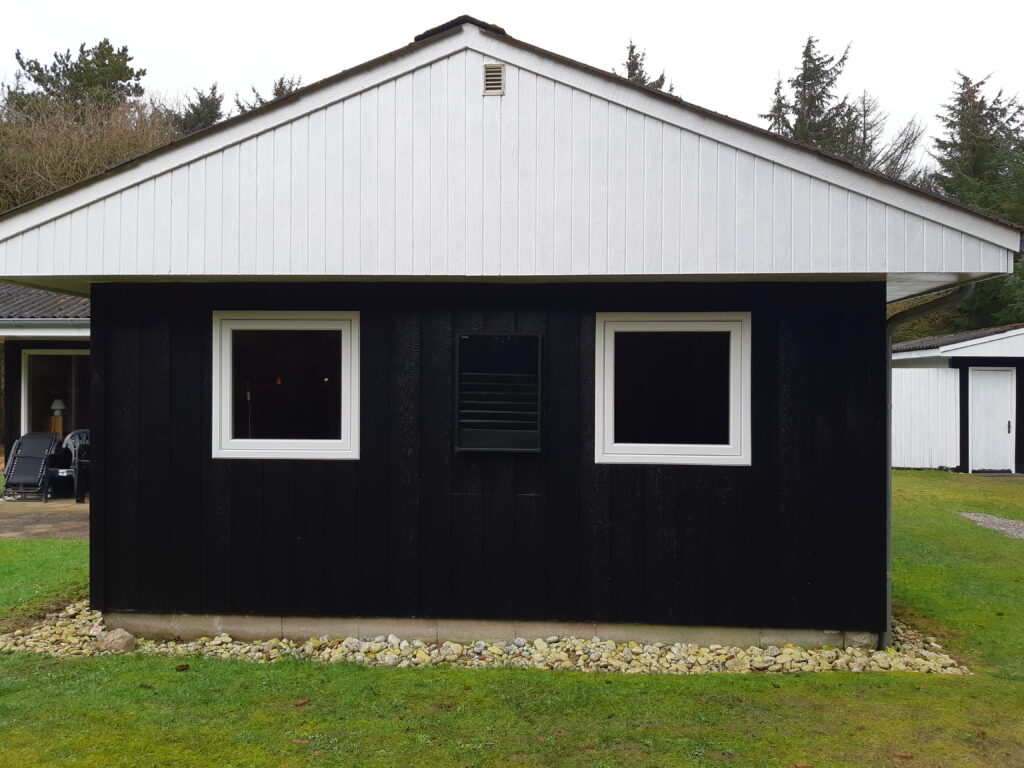Sort og hvidt sommerhus med to vinduer i plast