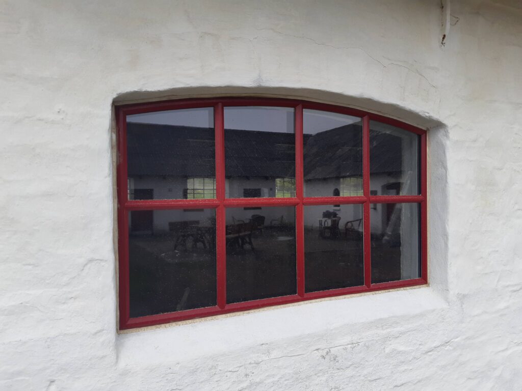 Rødt vindue i hvid murstensvæg